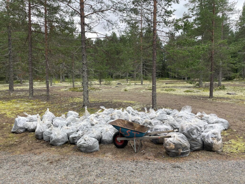 Wheel barrel surrounded by plenty of rubbish bags